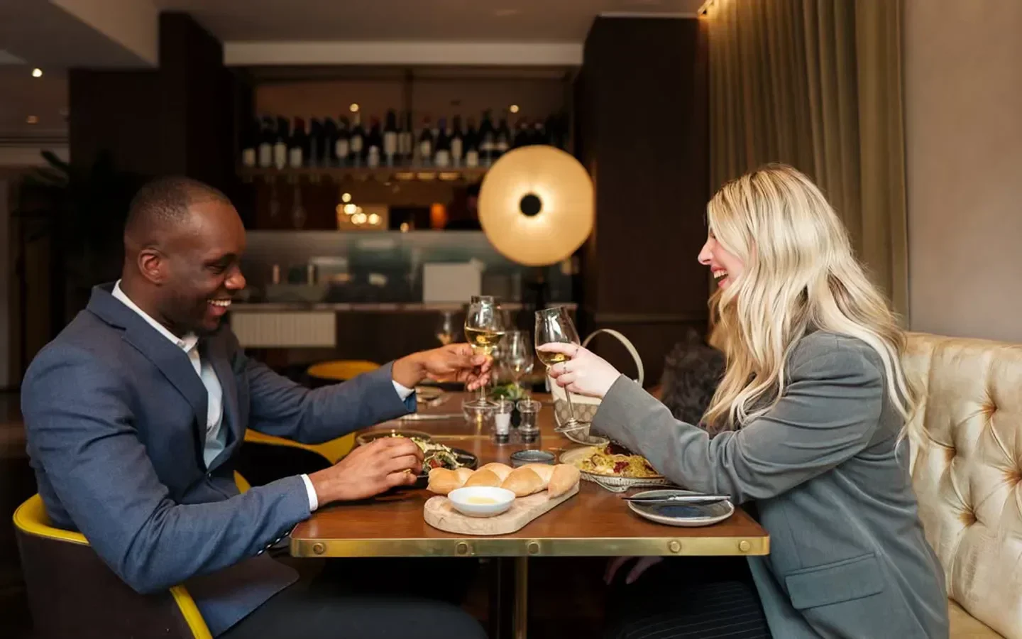 Couple toasting at 116 at The Athenaeum restaurant in London, enjoying dinner.