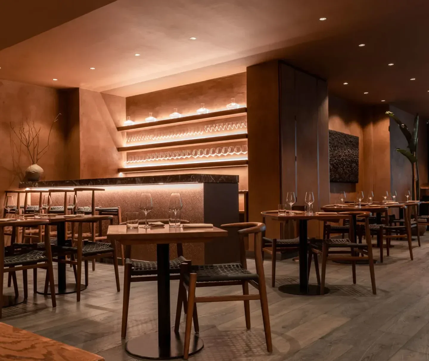 Interior dining space at Akoko restaurant in London, with elegant wooden tables and chairs.