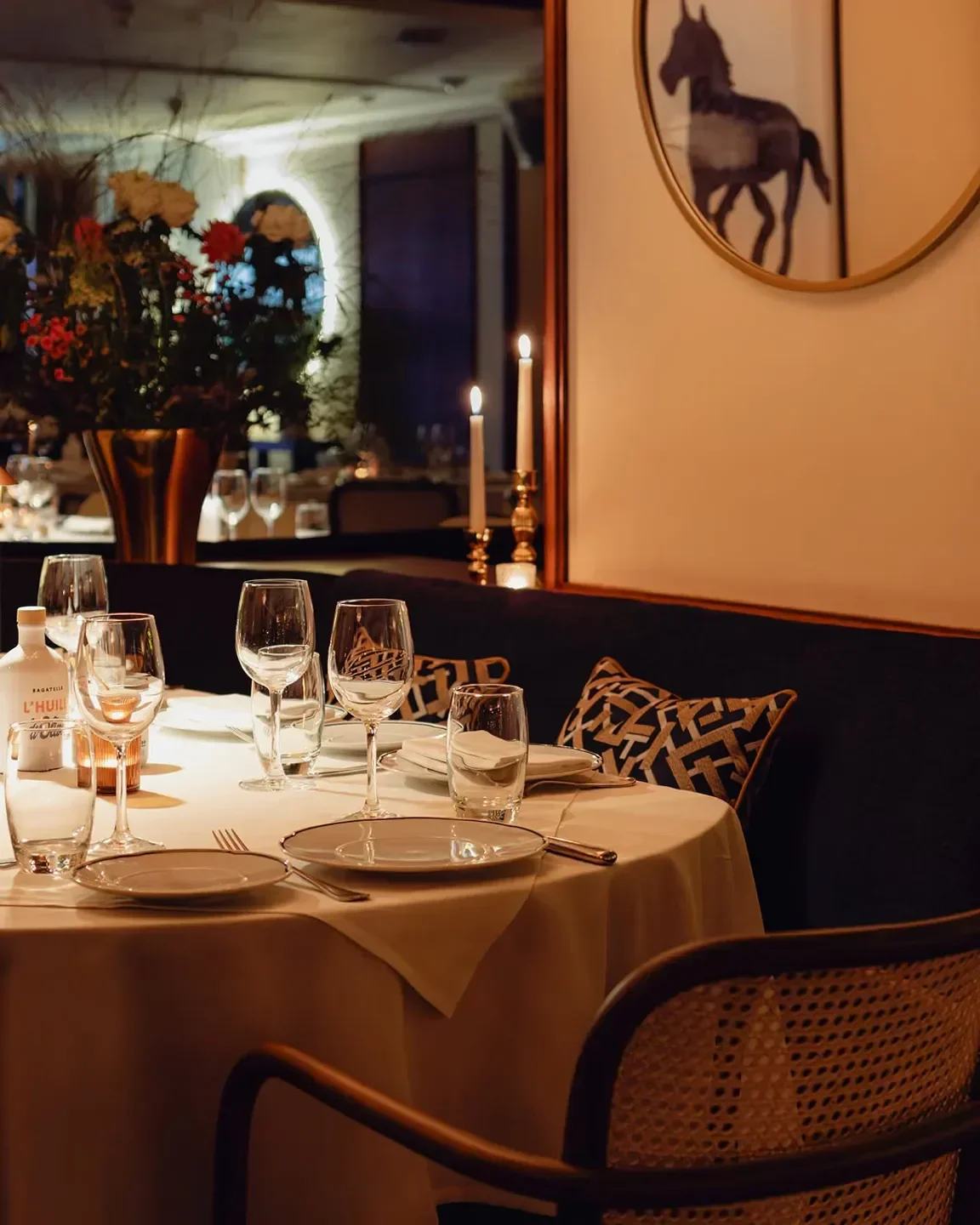 Elegant table setting at Bagatelle London restaurant, with candles and flower arrangement.