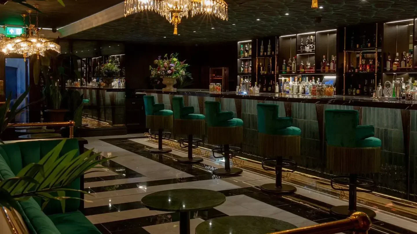 Interior of Bardo St James in London, featuring a stylish bar with green velvet seating