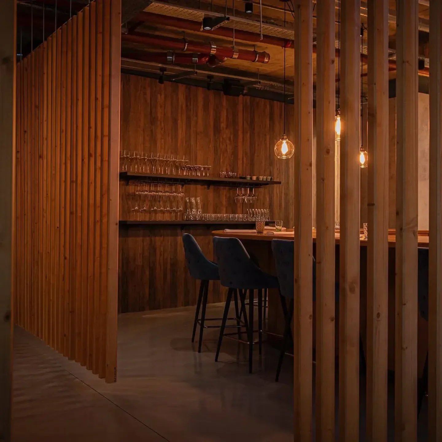 Interior of Behind restaurant in London with wooden accents and bar seating.