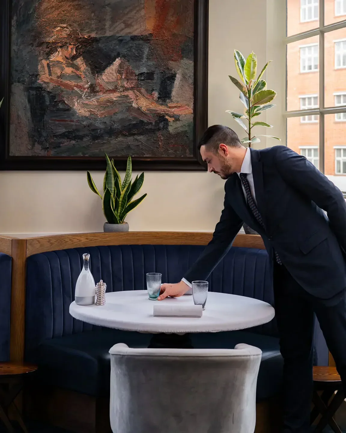 Server preparing table at Brooklands by Claude Bosi, elegant dining in London restaurant.