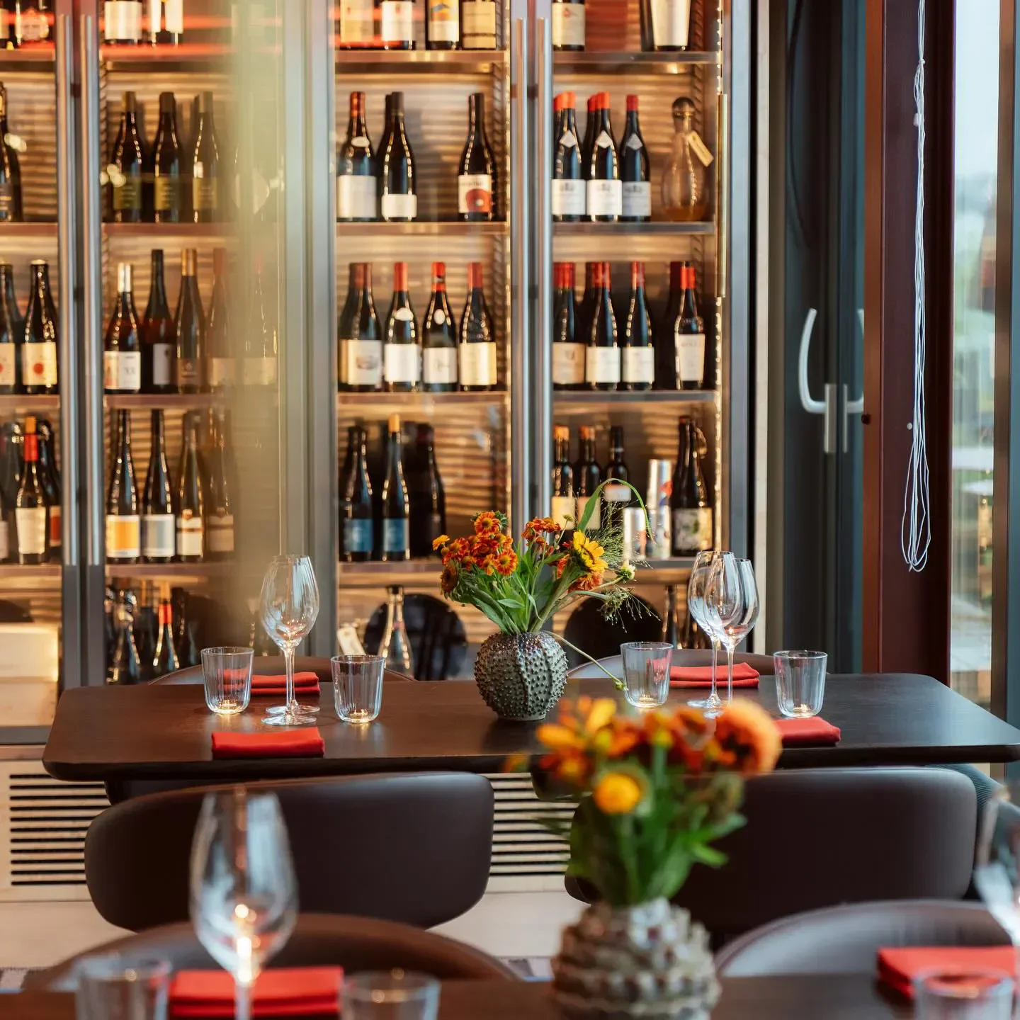 Elegant dining at Céleste restaurant in London, with wine selection and floral arrangements.