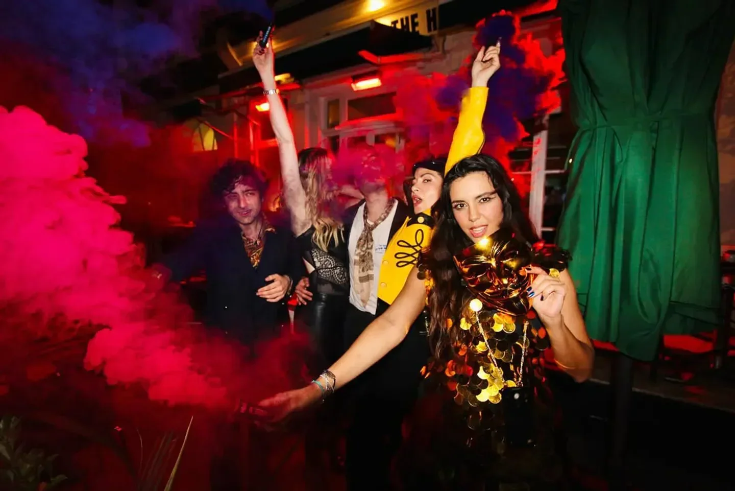 Party scene at Christabel's nightclub in London with colorful smoke and revelers