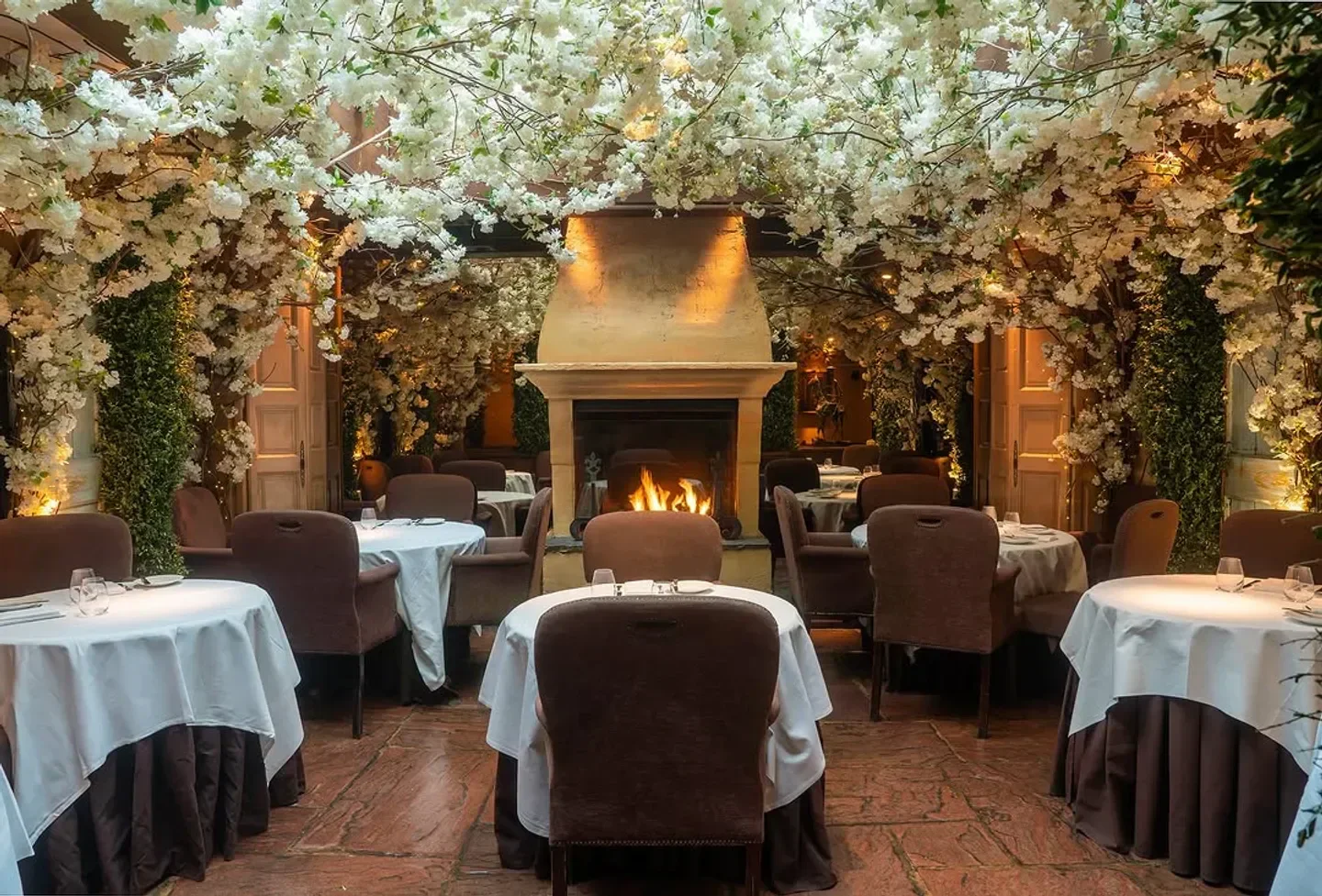 Cozy dining room at Clos Maggiore in London, featuring fireplace and floral decor
