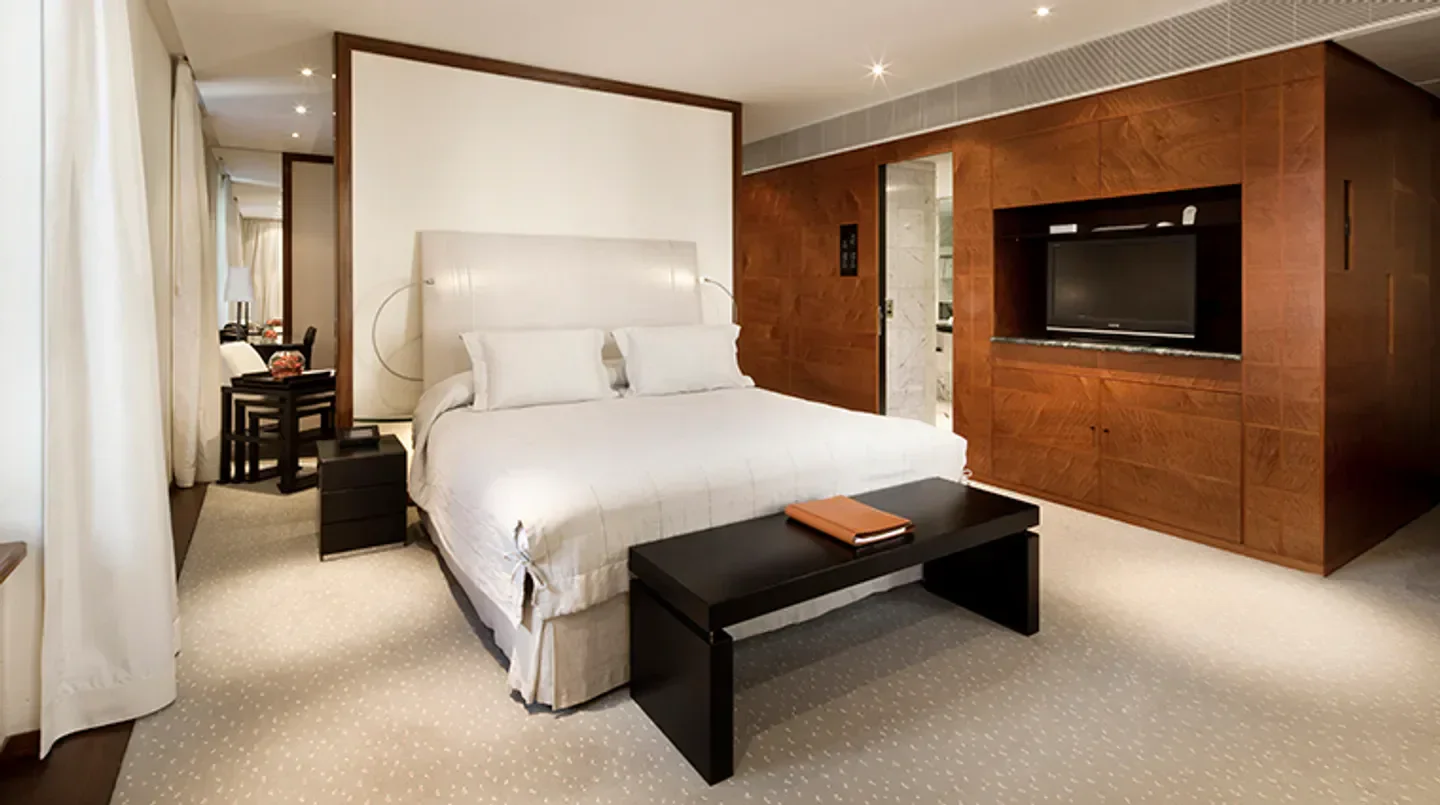 Luxury bedroom at COMO The Halkin, London, featuring a stylish bed and wooden accents in London.