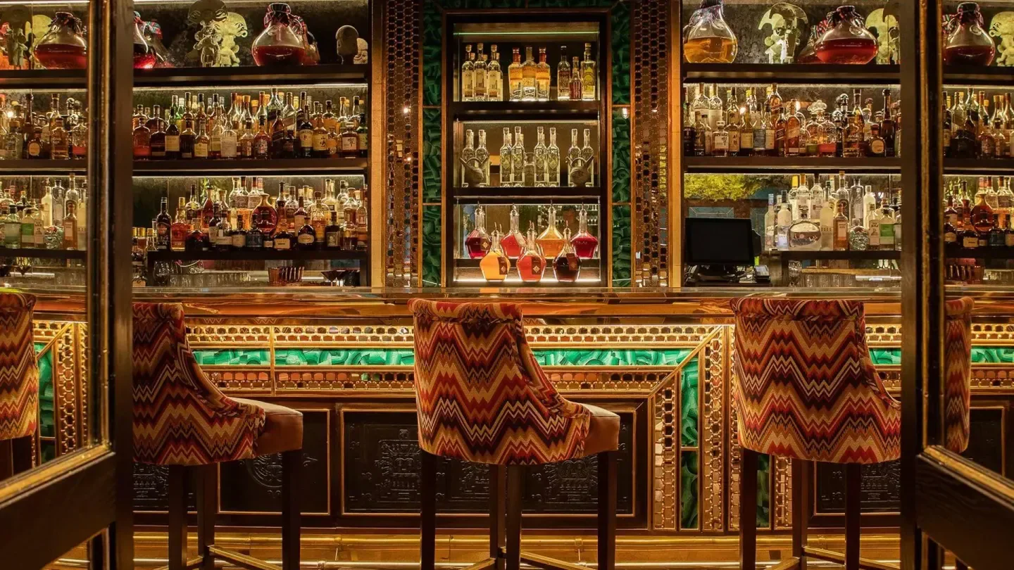 Interior bar at Coya Mayfair in London, featuring bottles and stylish seating.