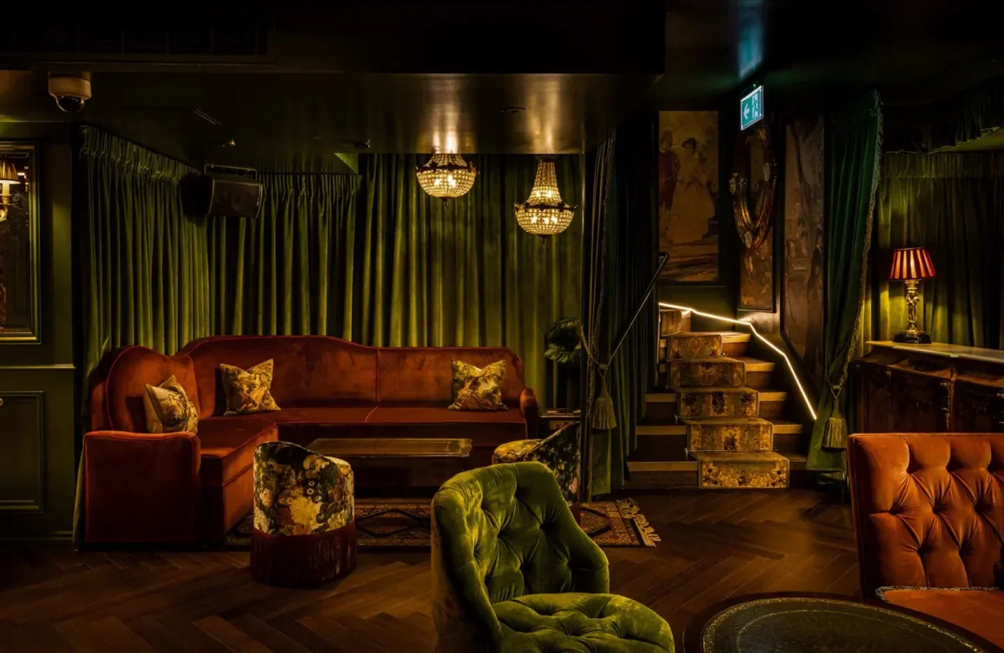 Elegant interior of Dear Darling nightclub in London, with plush seating and chandeliers.