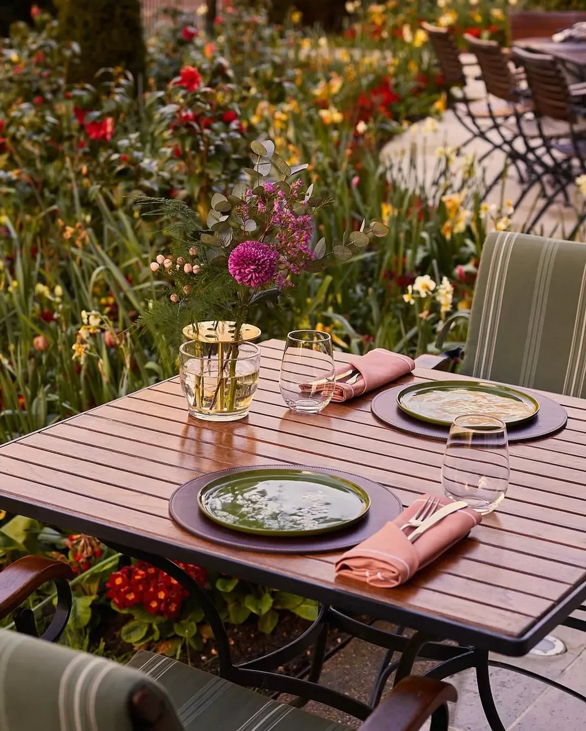 Outdoor dining at Dinner by Heston Blumenthal in London, table setting and garden view.