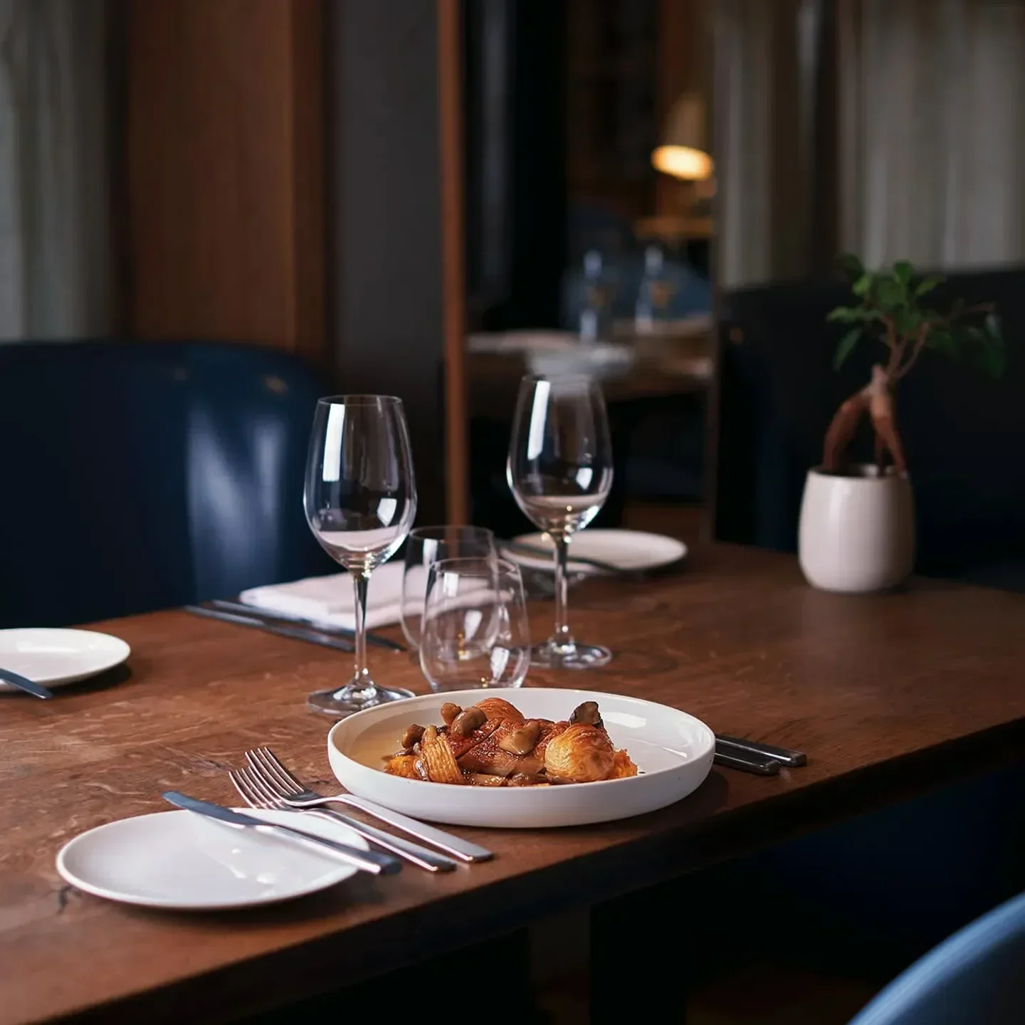 Elegant dining table at Elystan Street restaurant in London, with prepared dish and wine glasses.