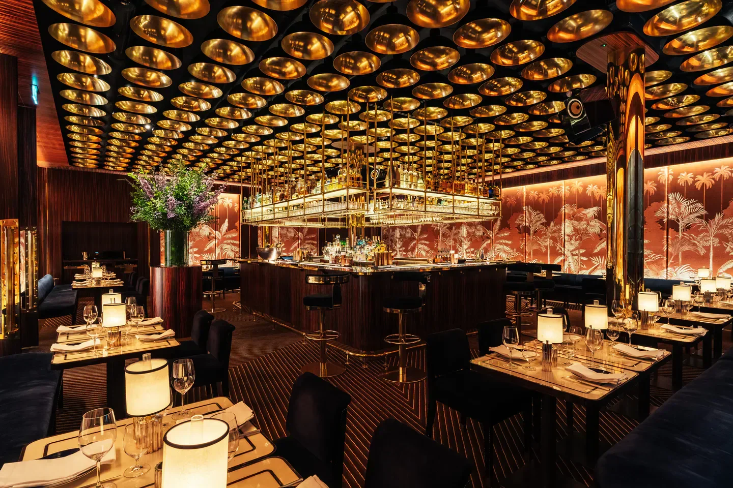 Interior of Isabel Mayfair, a stylish London restaurant with gold accents and bar.