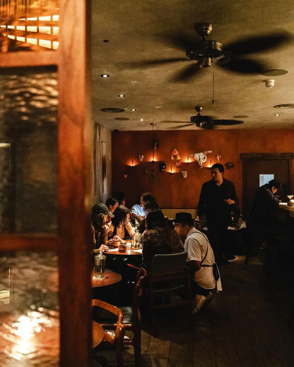 Cozy dining scene at KOL London restaurant, featuring a chef attending guests.