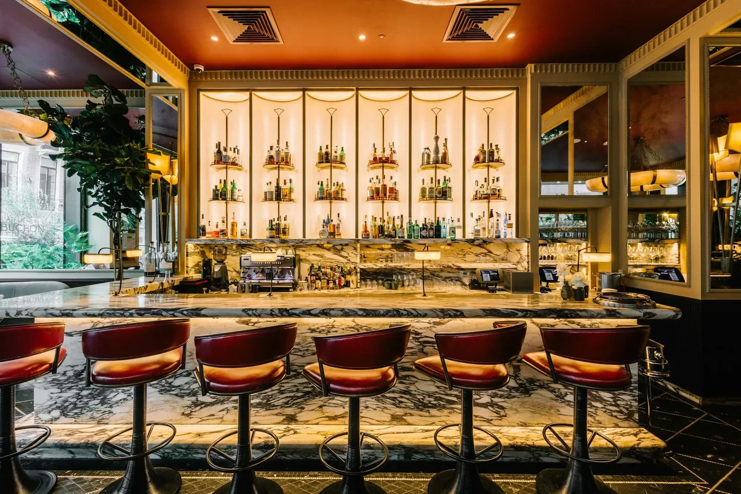 Elegant bar at L'Atelier Robuchon in London, featuring marble and stylish seating