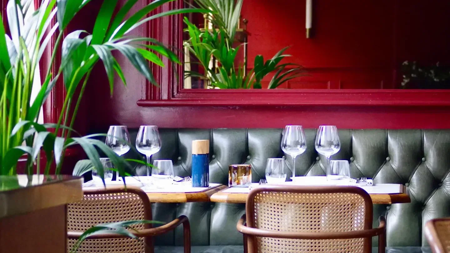 Stylish interior dining at Le Petit Beefbar London, with lush greenery and elegant details.