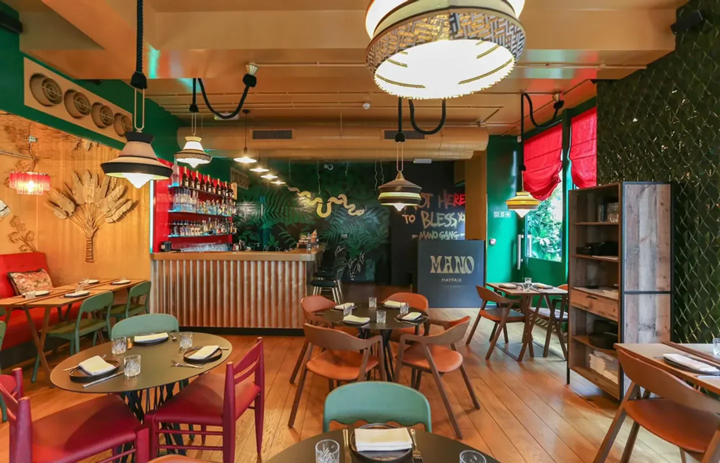 Interior of Mano Mayfair restaurant in London, featuring stylish decor and bar.