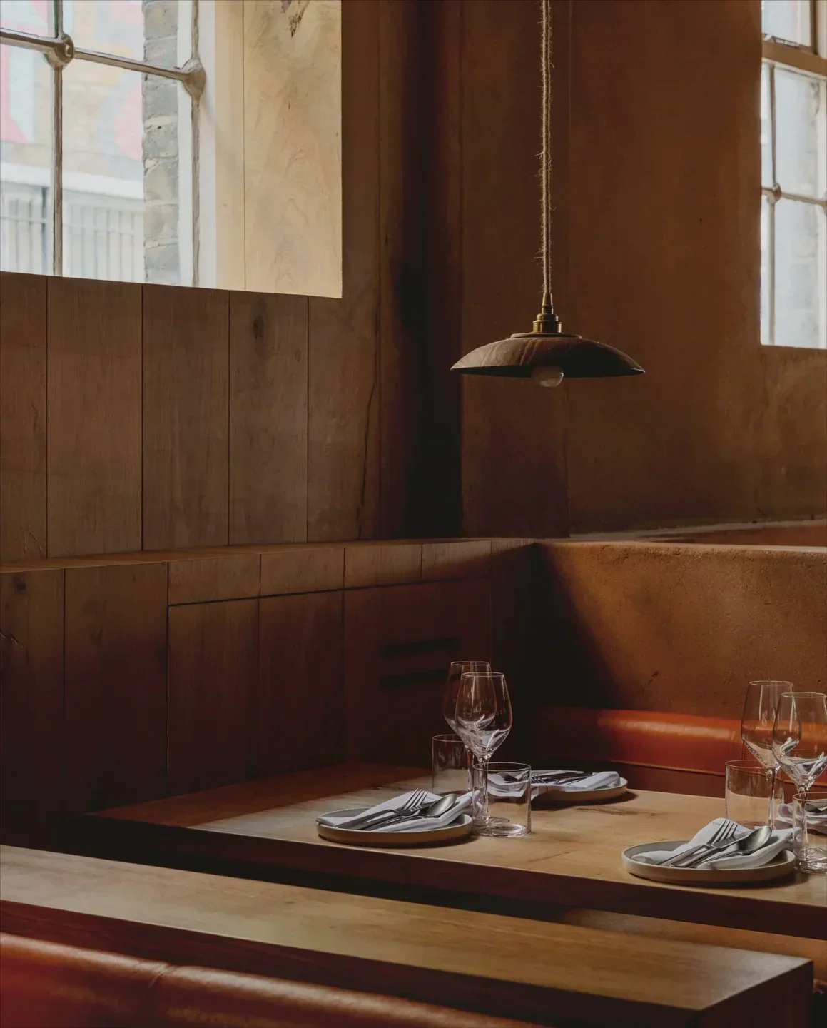 Cozy dining area at Manteca restaurant in London, with wooden tables and warm lighting
