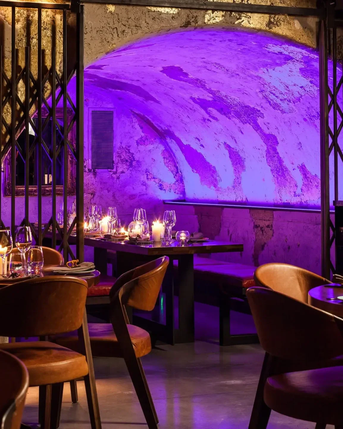 Cozy dining area at MNKY HSE in London, featuring dim lighting and purple ambiance.