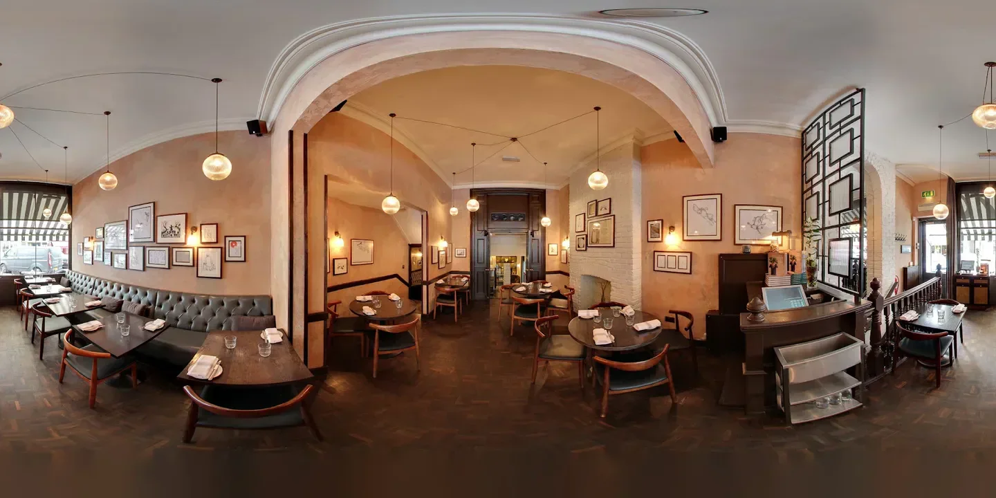 Interior of Odette's Restaurant in London, featuring art, tables, and soft lighting.