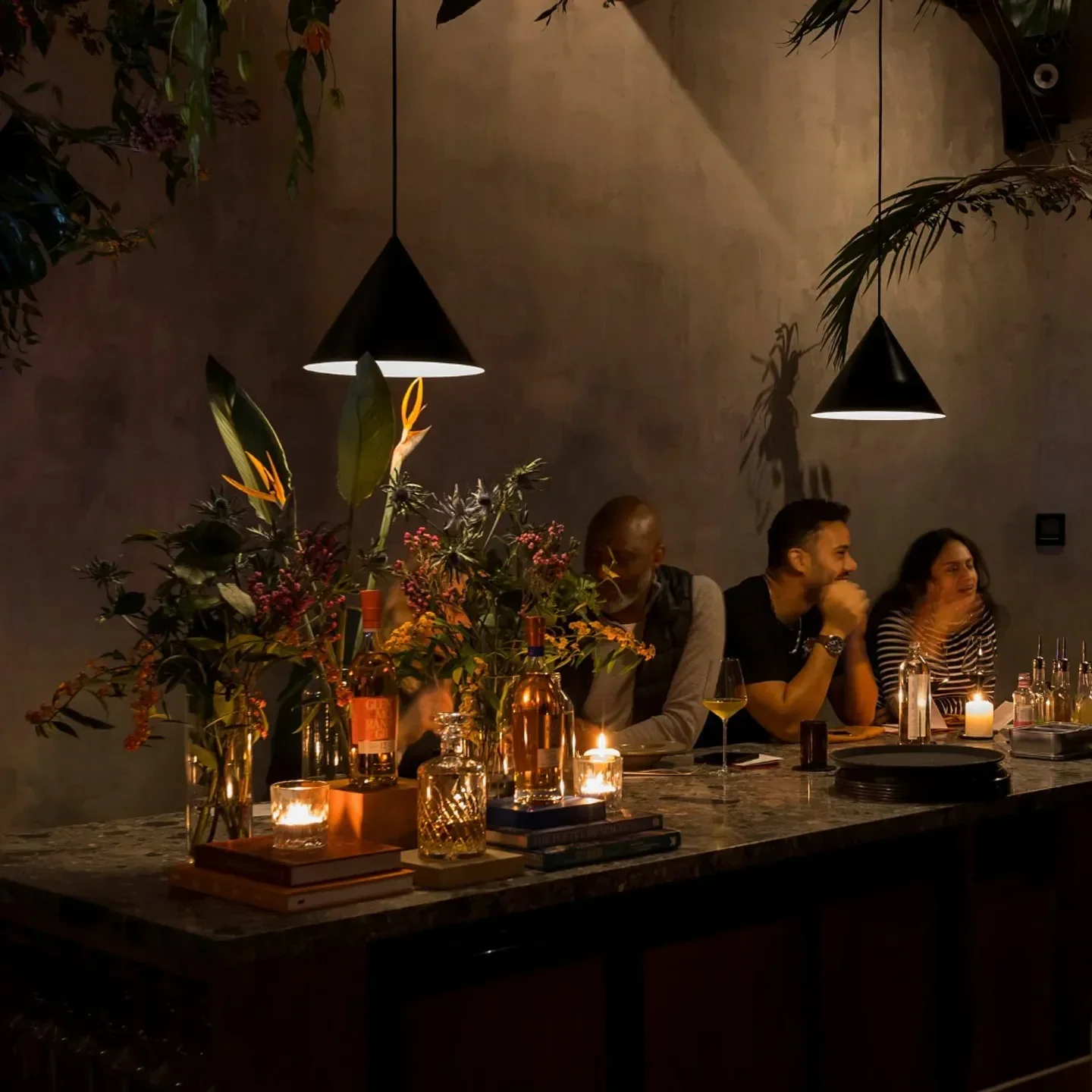 Cozy bar scene at Paradise Soho, London, with cocktails, flowers, and intimate lighting.