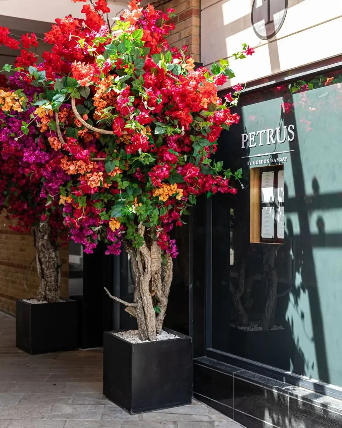 Entrance of Pétrus by Gordon Ramsay in London with vibrant floral decorations.