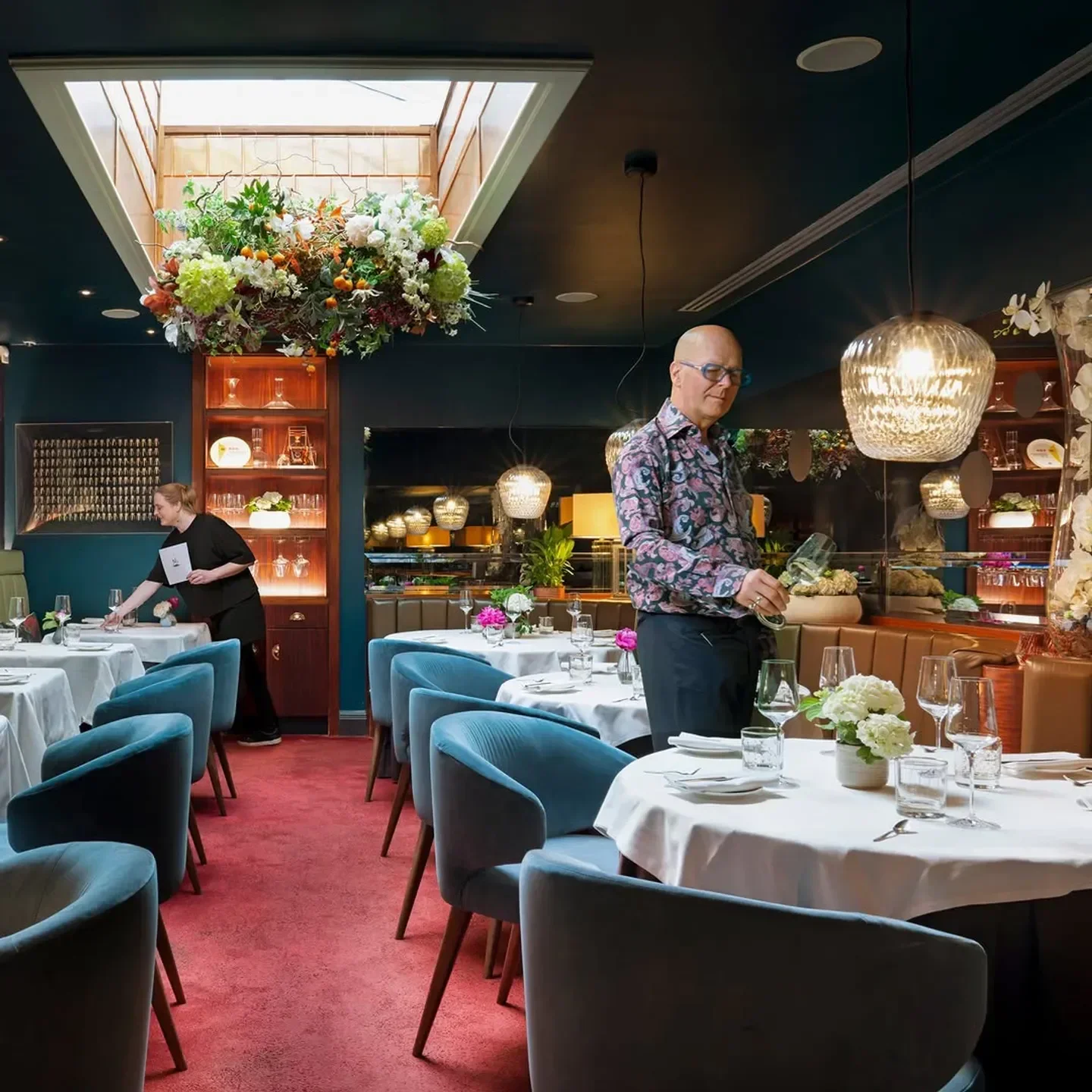 Elegant dining room interior at Pied à Terre, London, with floral decor and attentive service.