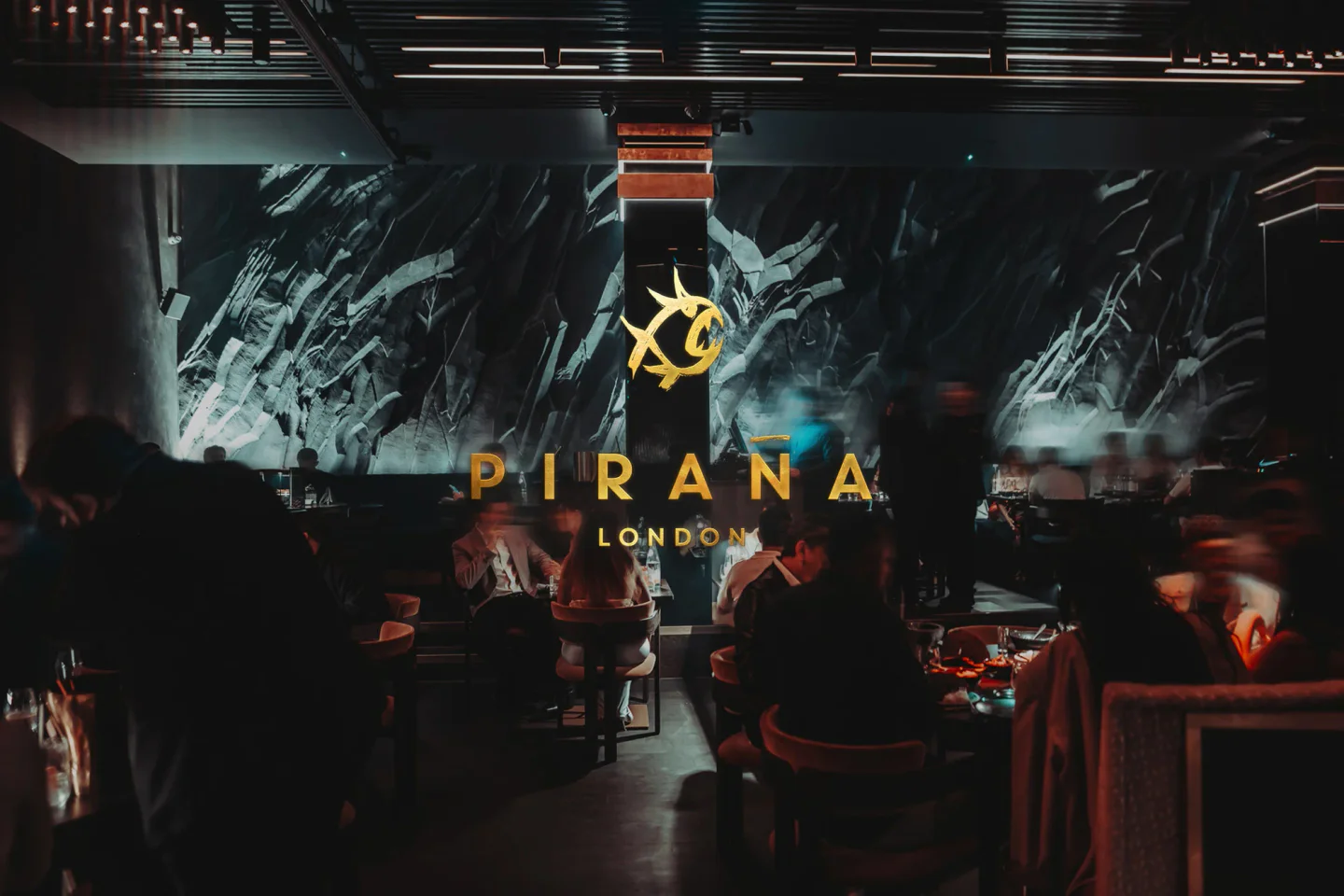 PIRANA London restaurant interior with striking abstract wall art and diners enjoying the atmosphere.
