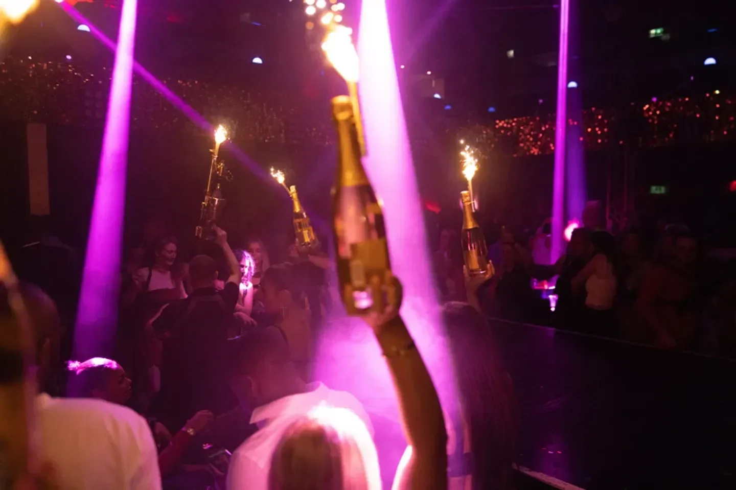 Champagne bottles with fireworks at Proud Late nightclub in London, party scene.