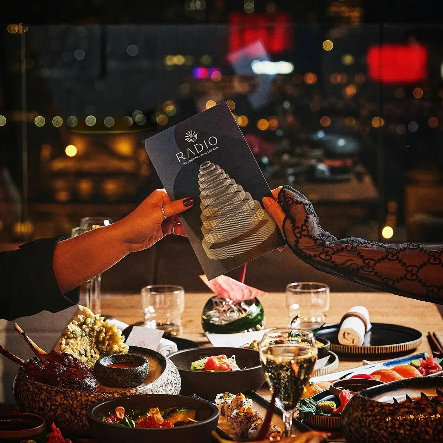 Dining at Radio Rooftop London with city views and selection of sushi and other foods.