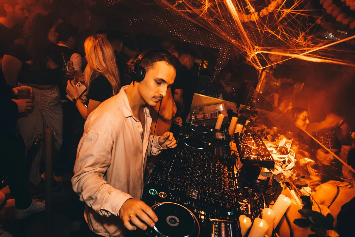 DJ at Raffles Chelsea nightclub in London, playing music for a lively crowd.