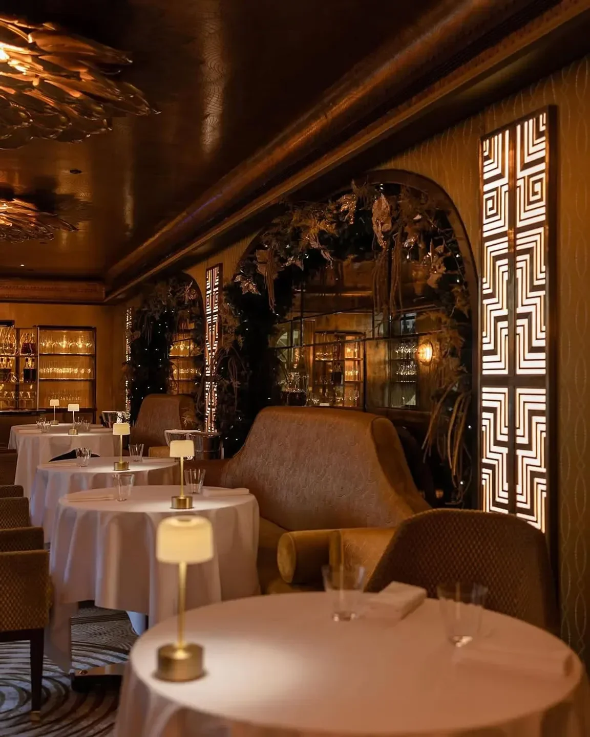 Restaurant 1890 by Gordon Ramsay in London: Elegant dining room with tables and ambient lighting.
