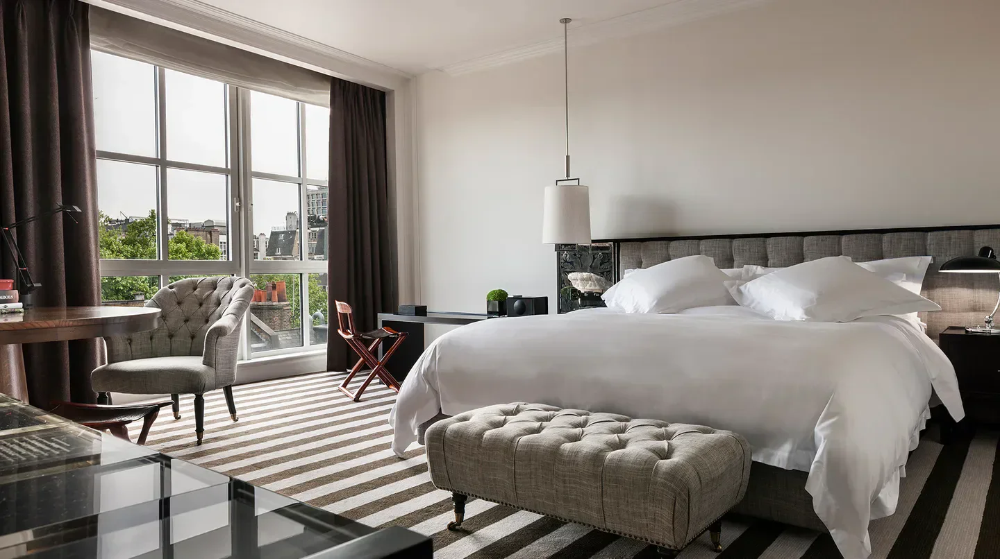 Elegant bedroom at Rosewood London hotel with city views in London.