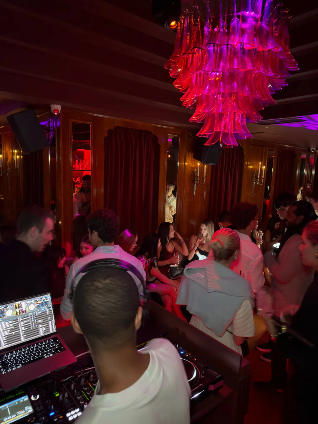 People enjoying the vibrant atmosphere inside Selene Club in London, with a DJ setup visible