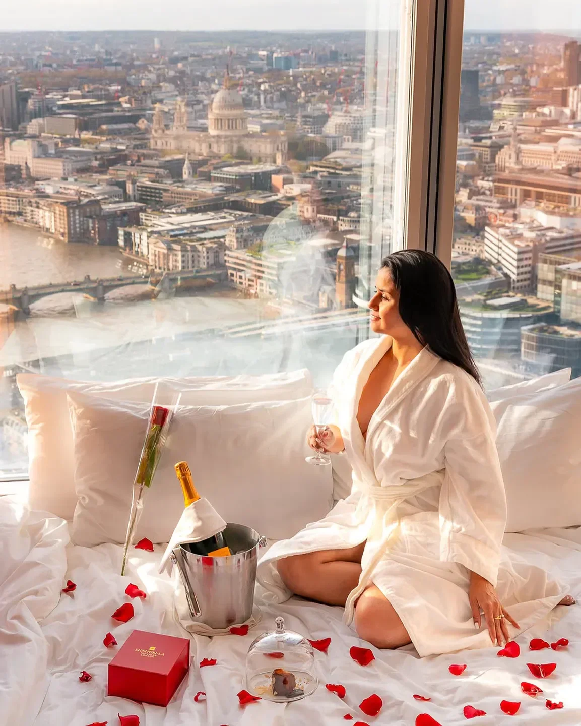 Woman enjoying champagne and views of London from Shangri-La The Shard, London hotel.