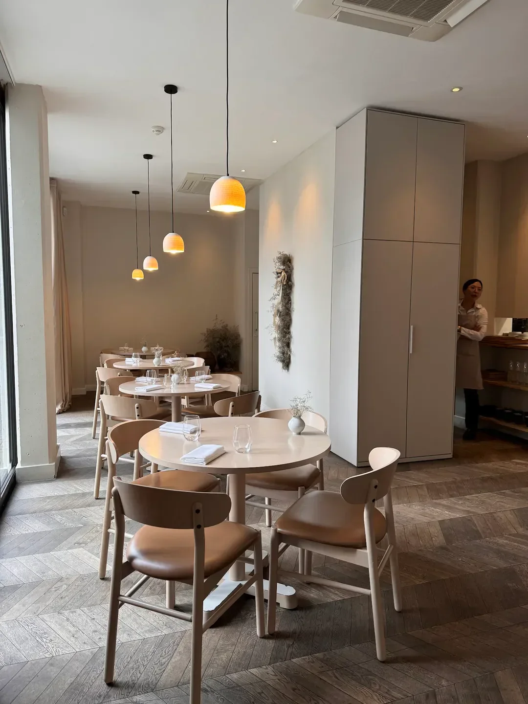 Elegant dining room interior at Sollip, a restaurant in London, featuring warm lighting