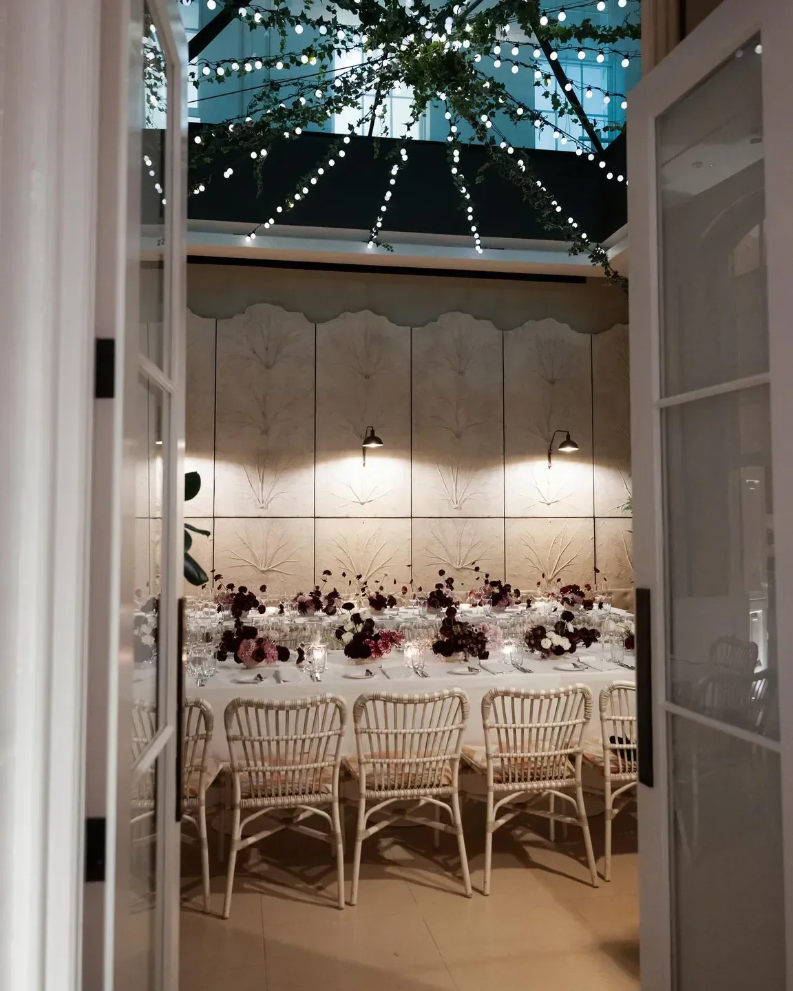 Elegant dining table at Spring restaurant in London, with floral decor and fairy lights.