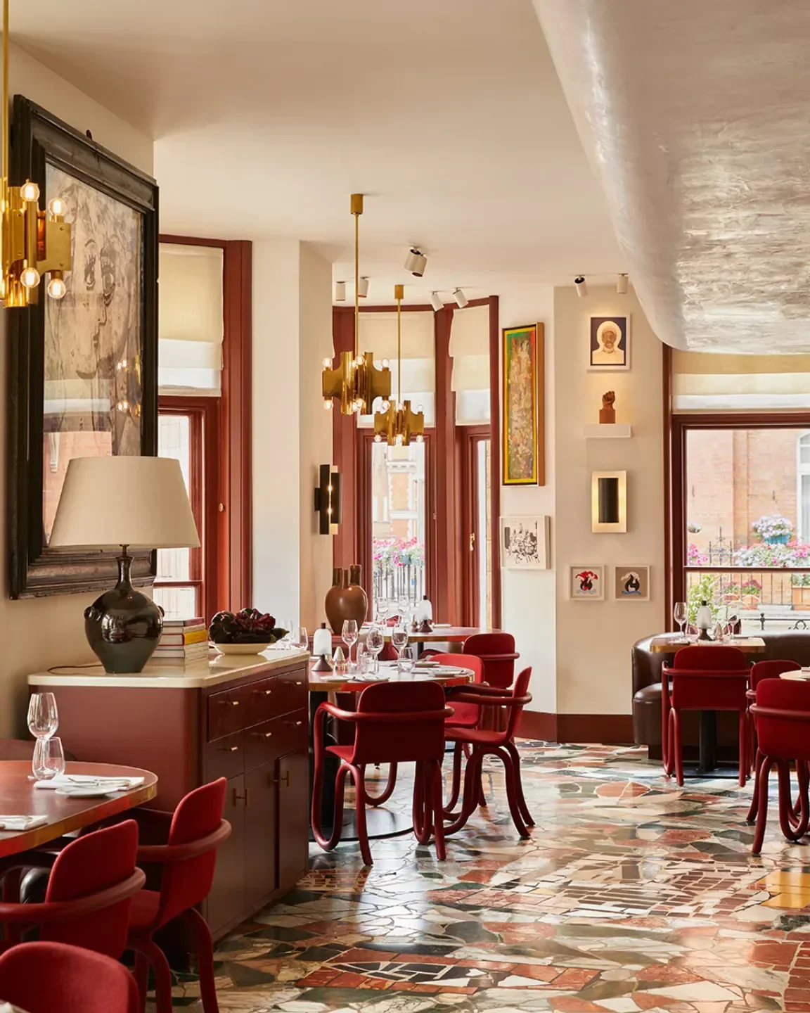 Interior of The Audley Public House in London with red chairs and artistic decor.