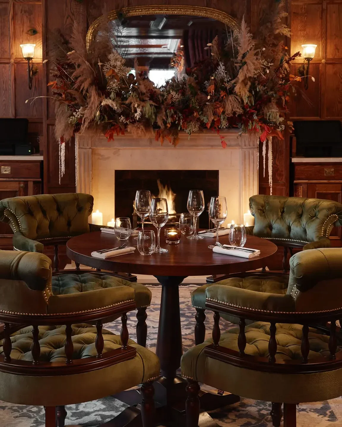 Cozy dining area at The Cadogan Arms restaurant in London, with a fireplace and chairs.