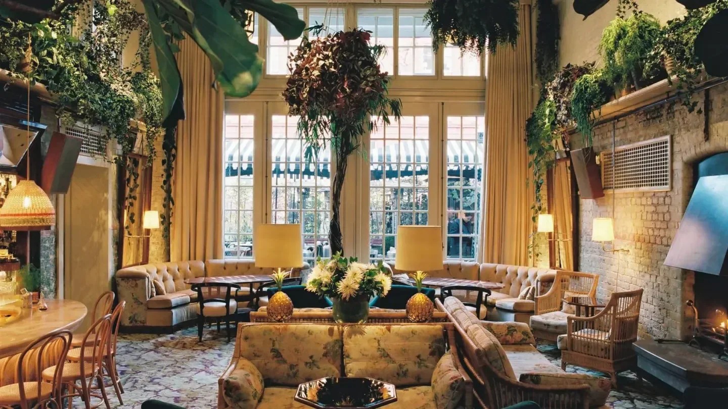 Elegant interior of The Chiltern Firehouse in London, with lush greenery and cozy seating