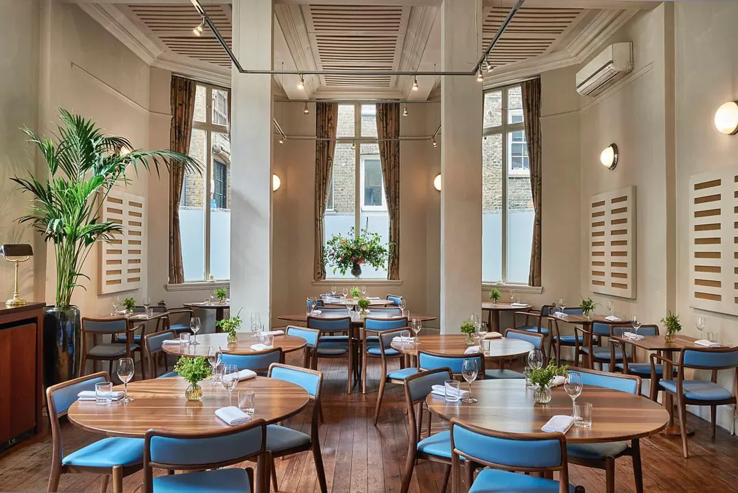 Interior of The Clove Club restaurant in London with tables set and decor.