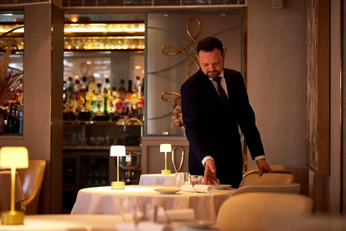 Elegant dining room at The Five Fields restaurant in London, with waiter setting the table.