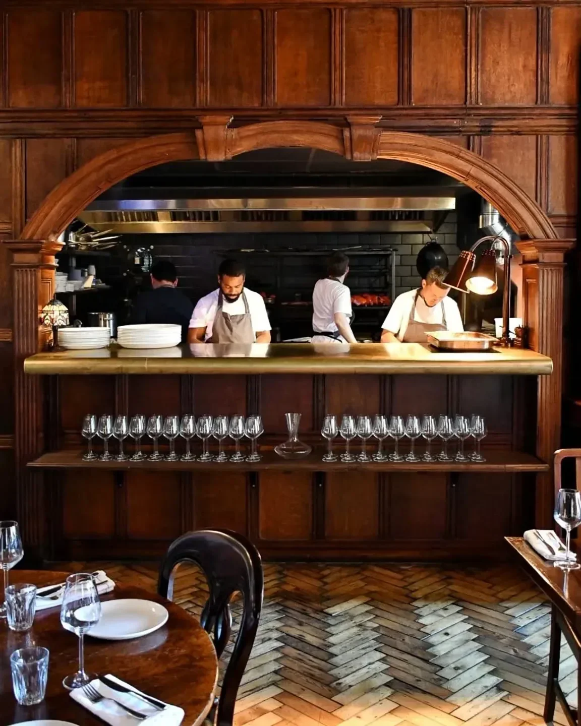 Chefs working in the kitchen at The Parakeet restaurant in London, wooden interior.