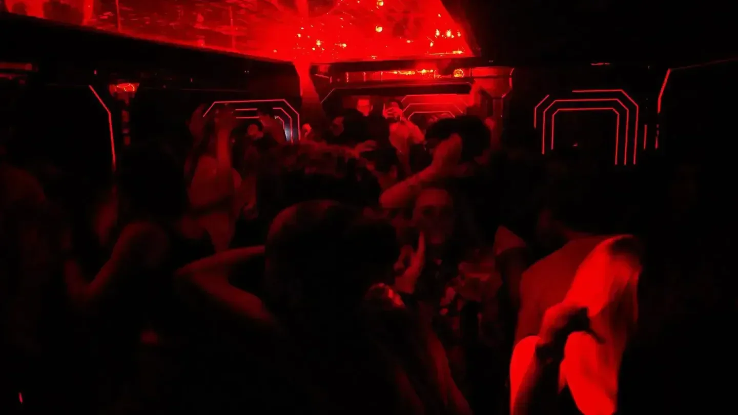 Energetic dance floor at The Scotch nightclub in London, illuminated by red lights