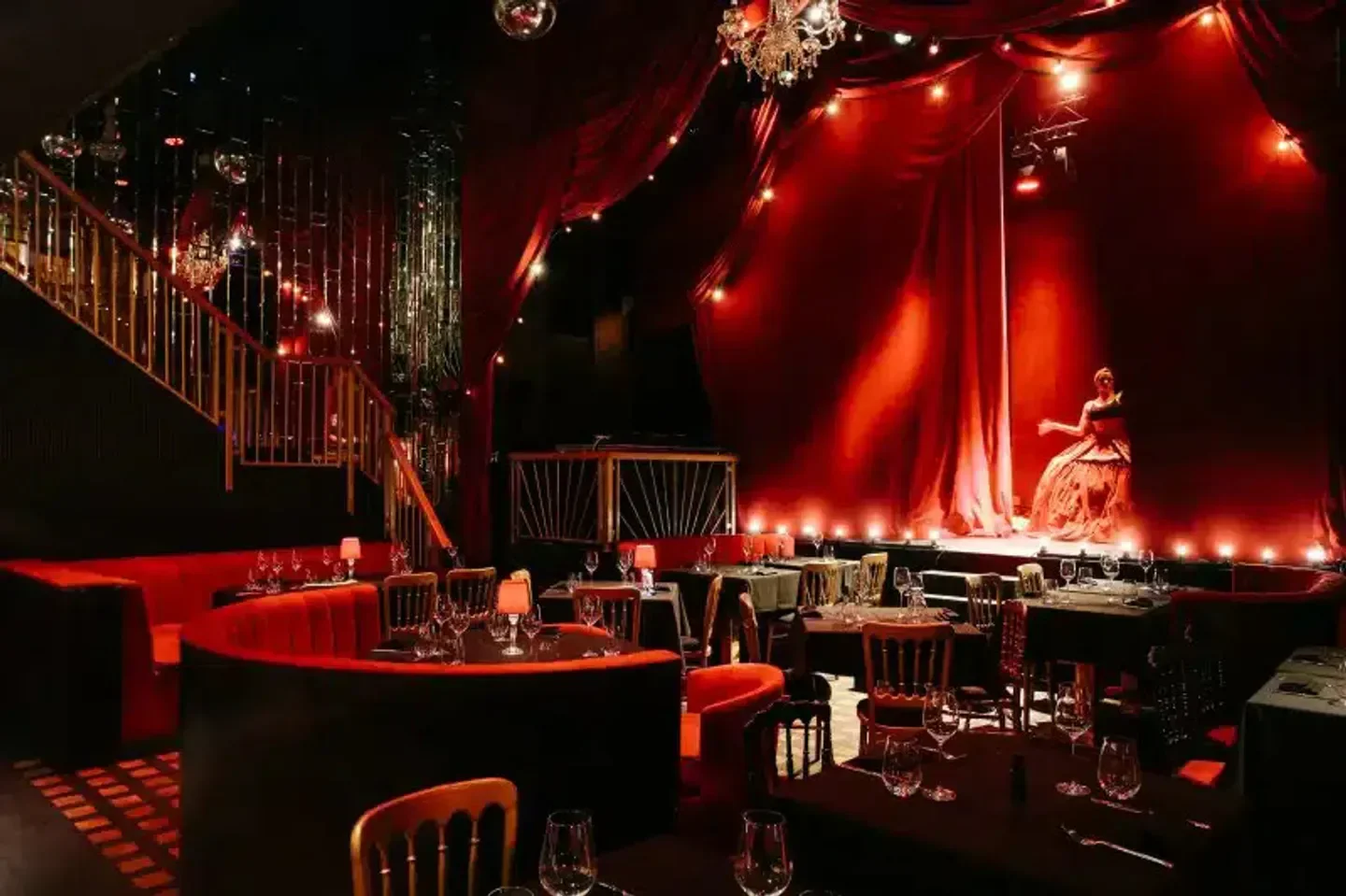 Interior of The Windmill Soho, London, with a stage and red decor.
