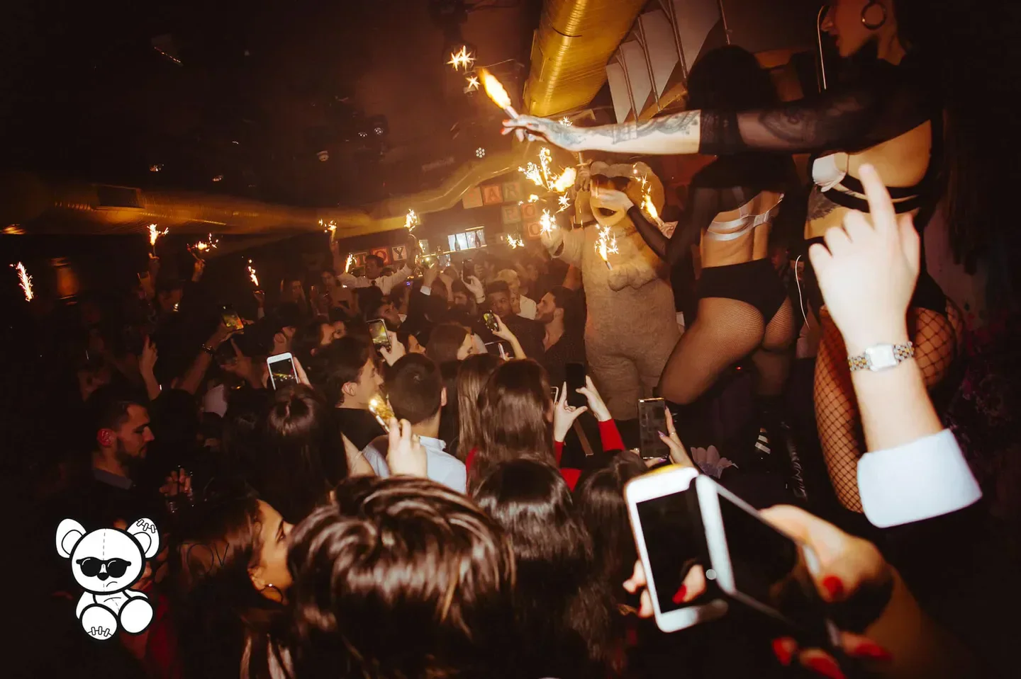 Party scene at Toy Room nightclub in London with sparklers and crowd.
