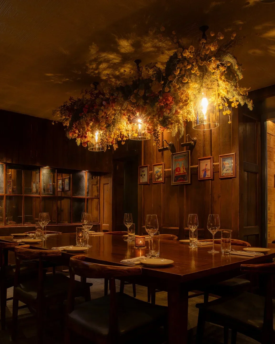 Cozy dining room at Trishna in London, featuring floral chandeliers and elegant table settings.