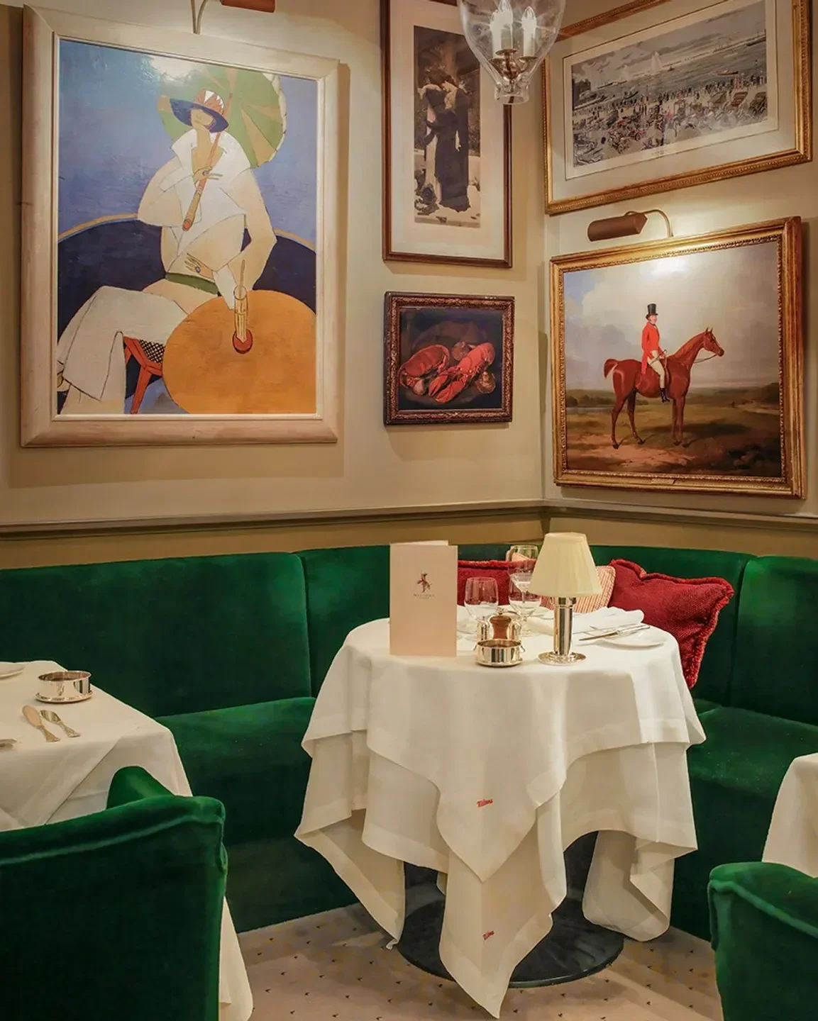 Elegant dining room interior at Wiltons Restaurant in London, with art and tables.